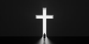 A silhouette of a man standing in front of an illuminated white cross