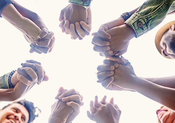A group of people praying in a circle