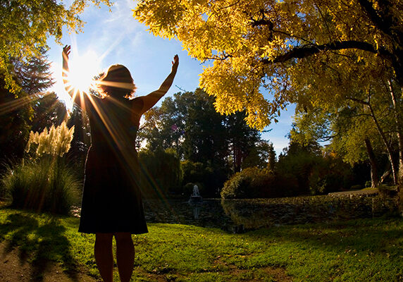 A woman with arms outstretched to the sun
